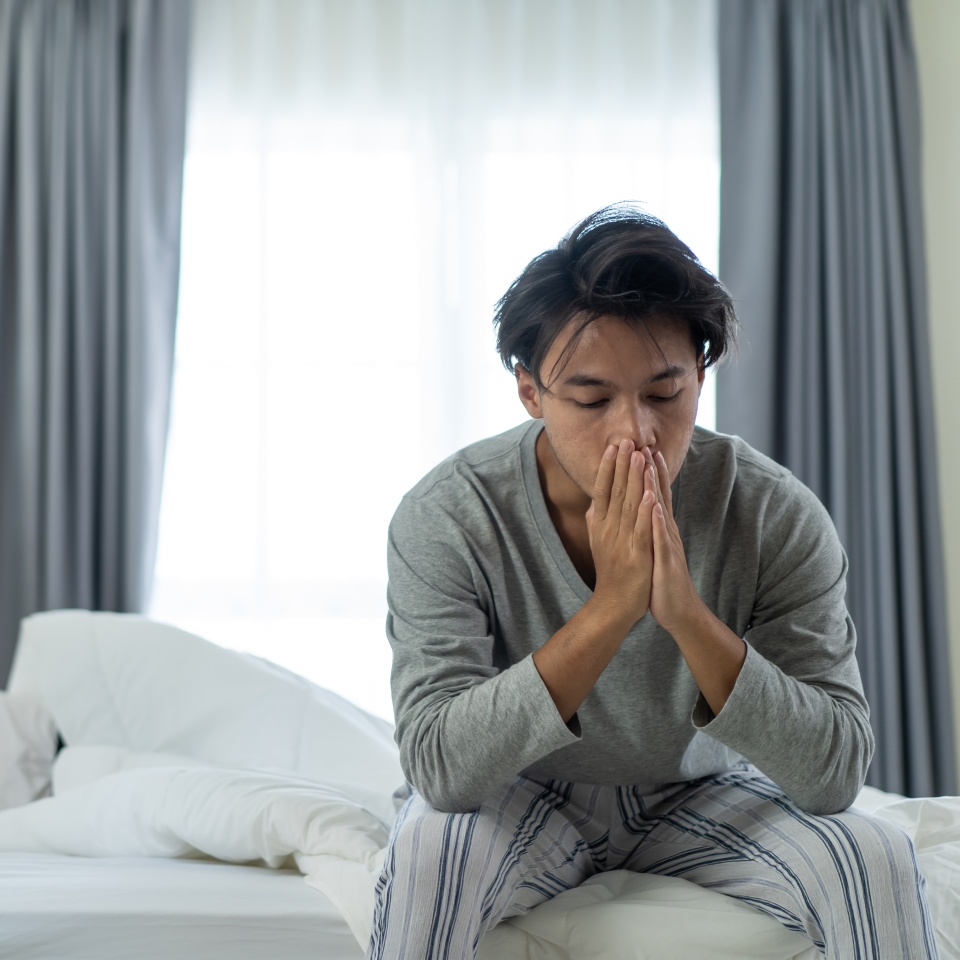 Asian young man feel angry girlfriend having conflict domestic problem. New marriage man and woman feel heartbroken for quarrel conflict while sit on bed in bedroom. Family problem-separation concept.