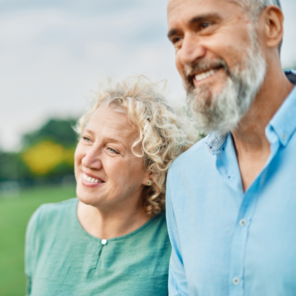Portrait of a happy middle aged woman and active middle aged white couple having fun walking holding hands and bonding in park outdoors