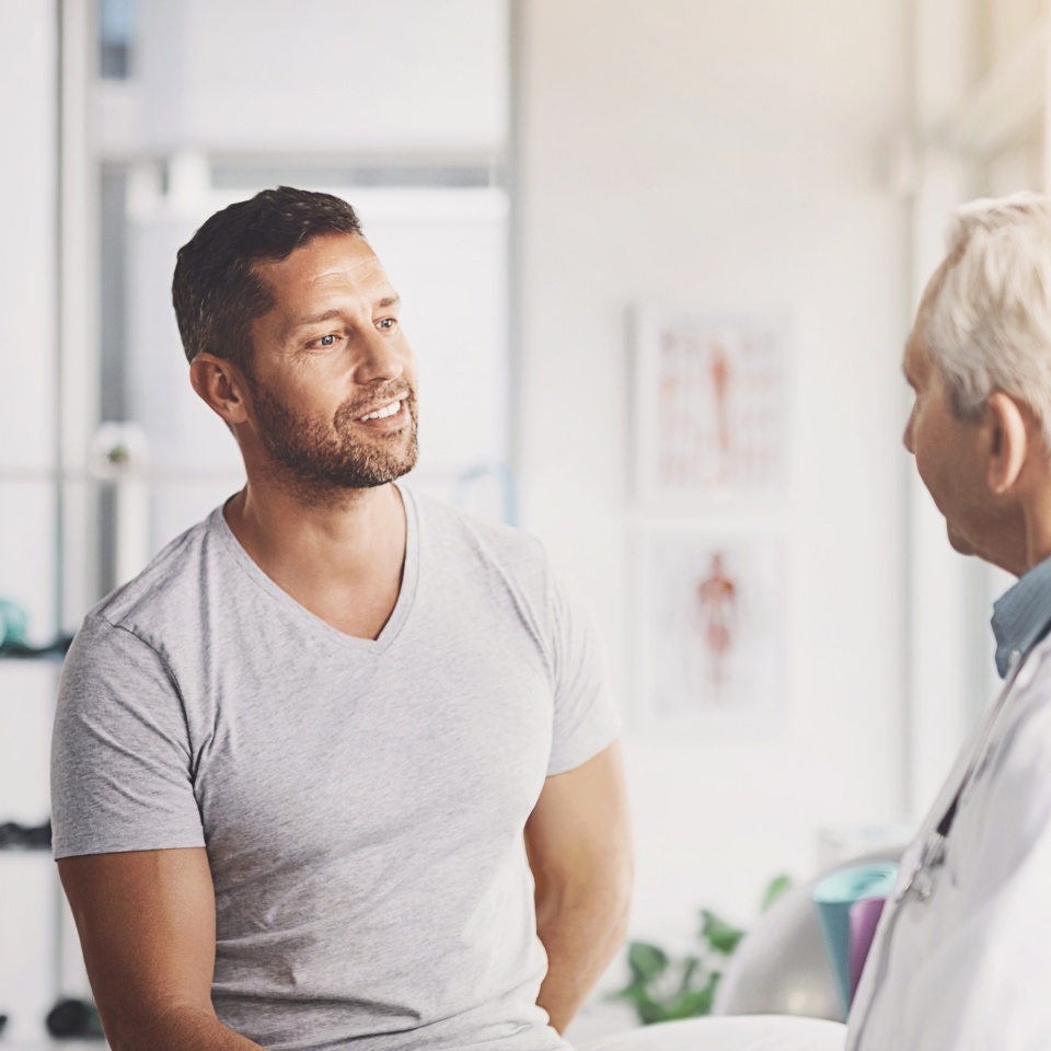 Doctor, office and man with discussion in consultation for medical treatment, planning and feedback. Healthcare, people and mature professional with advice for physiatry, checkup and information