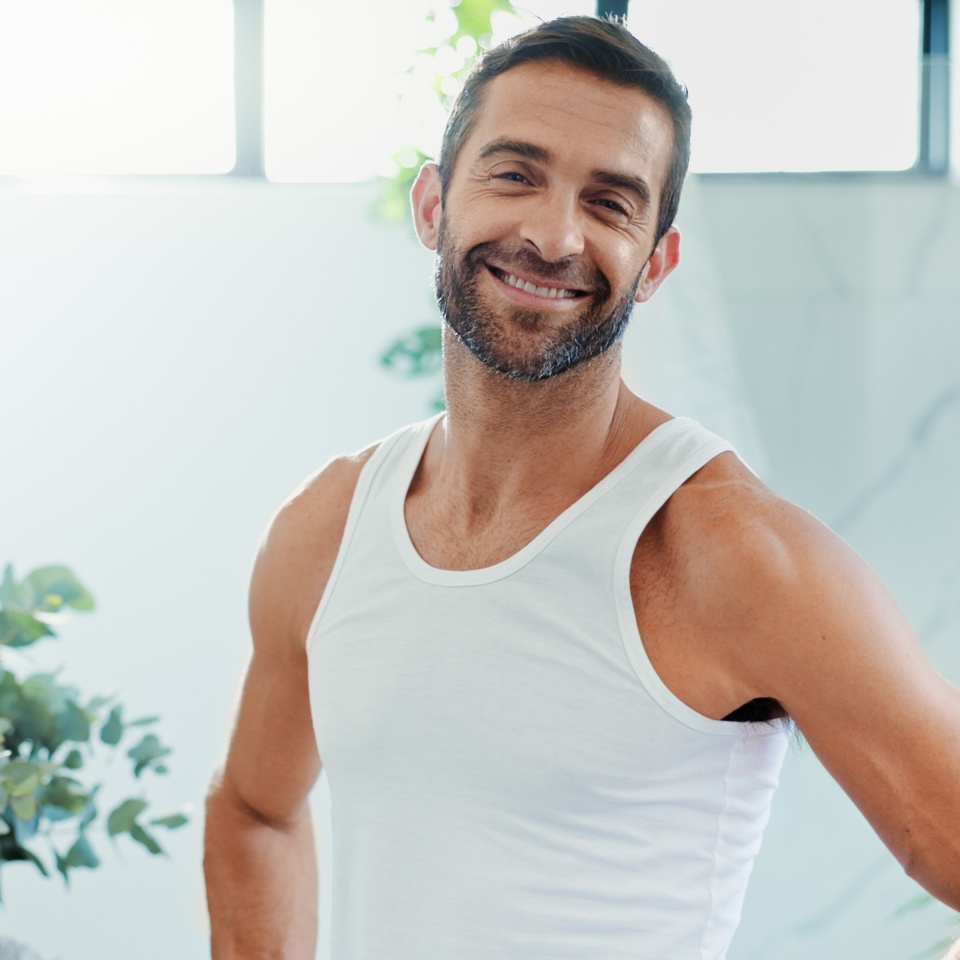 Portrait, smile and man in bathroom, skincare and confidence with routine, hygiene and cosmetics. Face, apartment and happy person with pride, grooming and treatment with dermatology, home and beauty